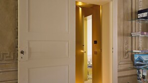 En hotelindgang med en hvid dør, en gang der fører til et værelse, og et udstillingsskab med bøger.