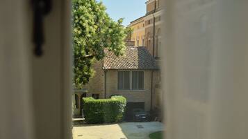 A courtyard with a central circular garden, a building with a tiled roof, and a clear blue sky.