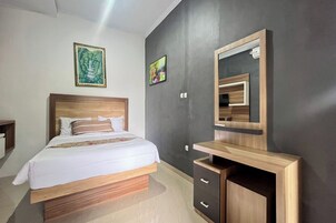 Un dormitorio moderno con una cama de madera, un escritorio empotrado y un espejo grande.