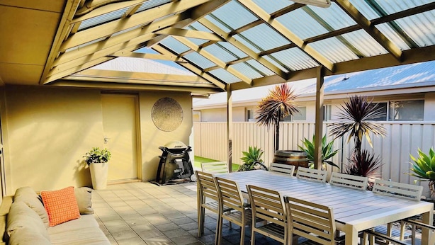 A covered patio with a table and chairs, a sofa, and potted plants. - Guichen Villa 3 - Wi-Fi, Pets welcome outside (Robe)