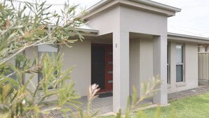 A modern building with a flat roof, a red door, and a number '3' on the wall. - Guichen Villa 3 - Wi-Fi, Pets welcome outside (Robe)