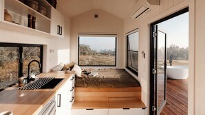 Un interior moderno con una cocina, un ventanal y vistas al exterior.