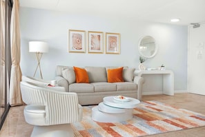 A modern living room with a sofa, armchair, coffee table, and a rug.