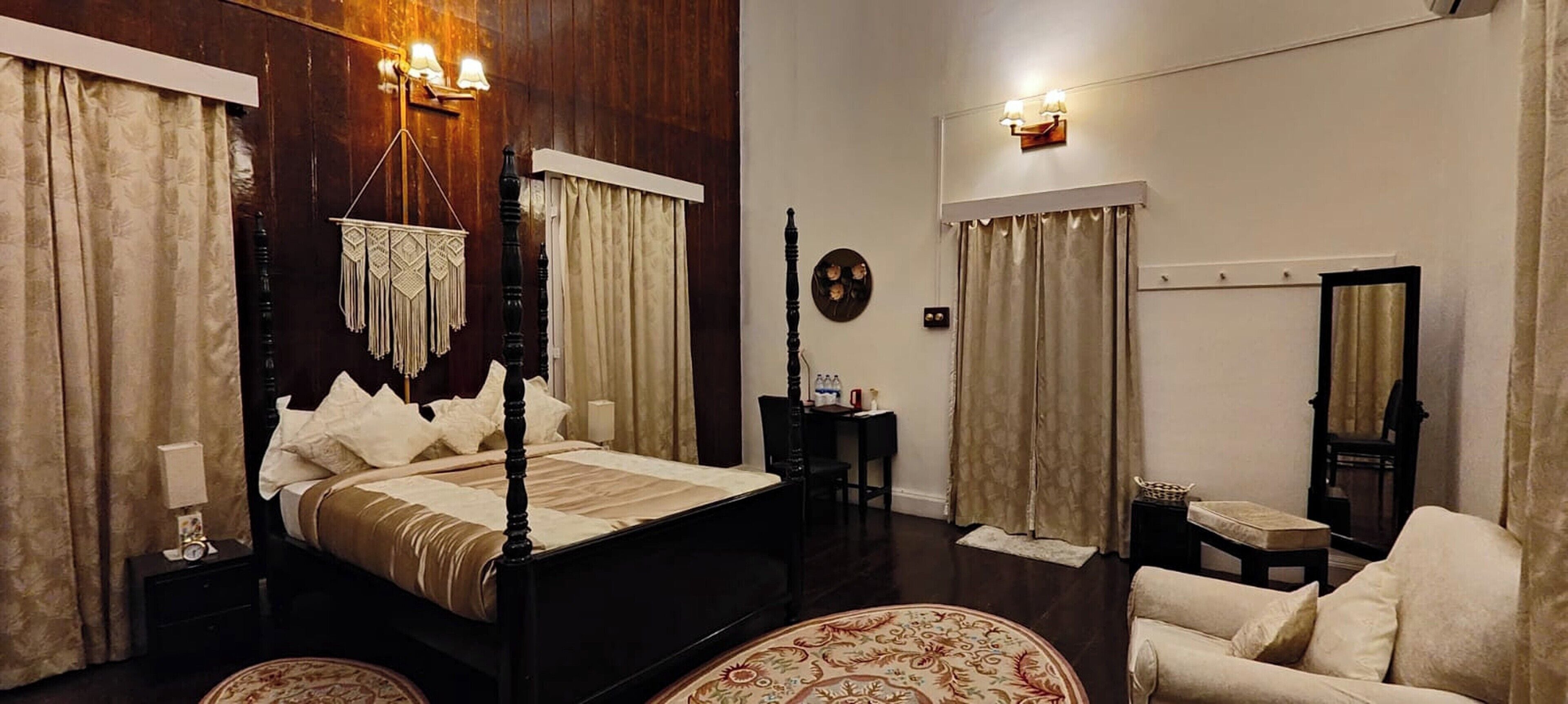 Un dormitorio amplio con una cama grande, una zona de estar con sofá y una mesita.