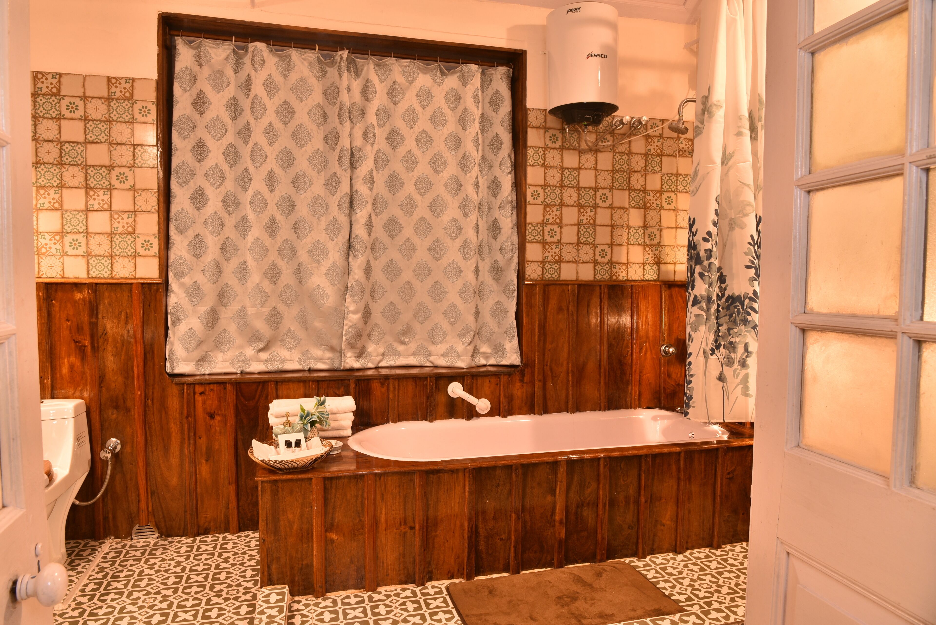 Un baño con bañera de madera, ducha e inodoro.