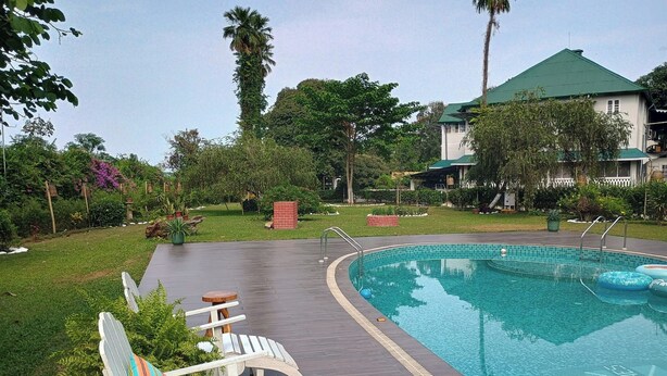 Une piscine avec des chaises longues et une terrasse en bois.