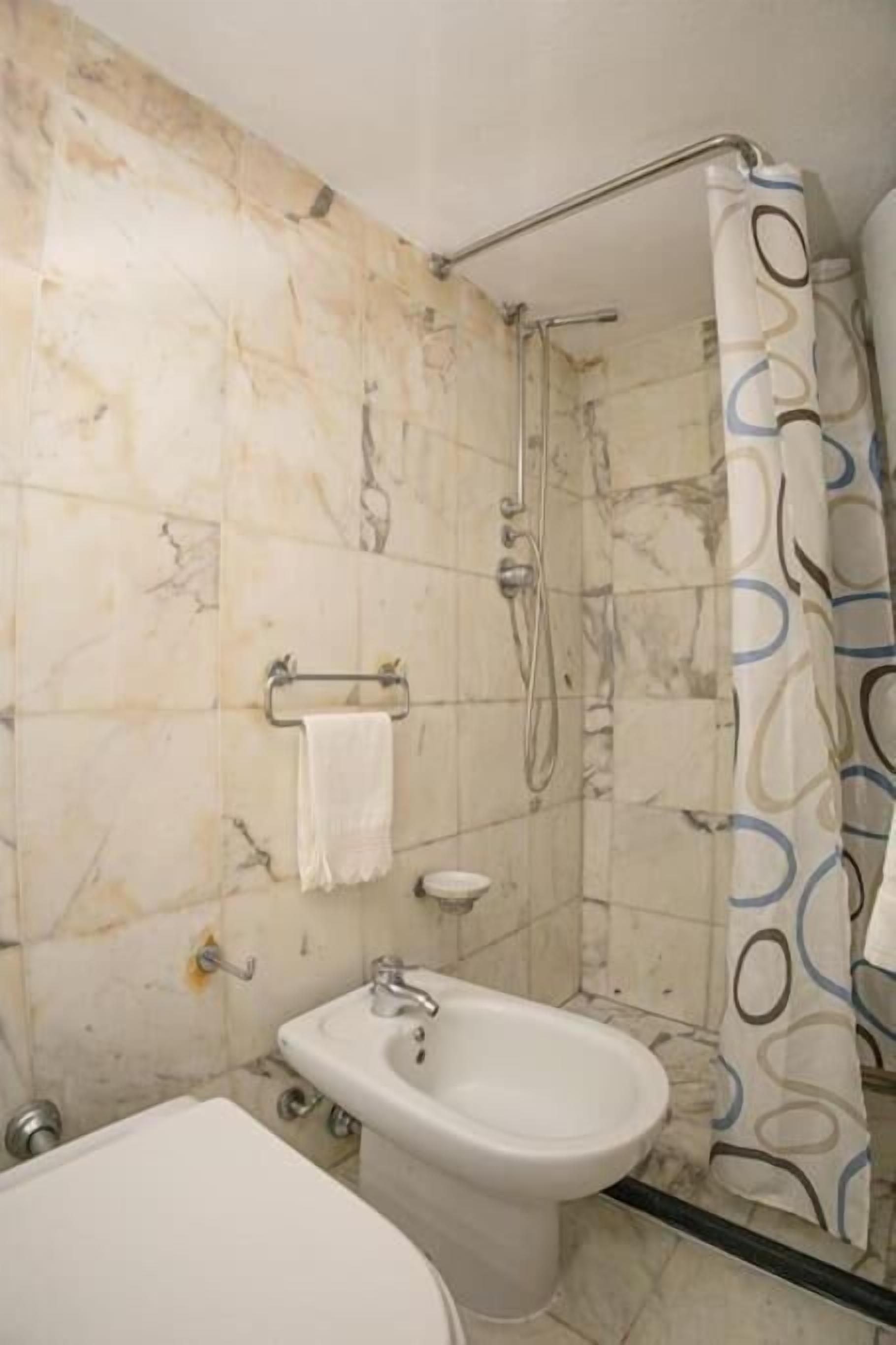 Ein Badezimmer mit Dusche, Bidet und Waschbecken.