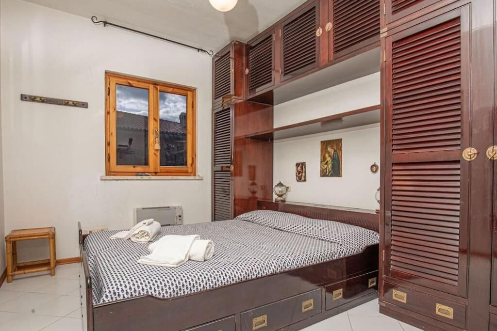 Una camera da letto con un letto, un'armadietto in legno, una finestra e un comodino.