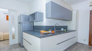Une cuisine moderne équipée d’un réfrigérateur encastré, d’un évier et d’un plan de travail sur lequel sont posés quelques objets.