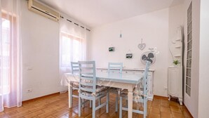 Ein Essbereich mit Tisch und Stühlen, einem Wandventilator und einer Heizung.
