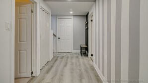 A hallway with white walls, a wooden floor, and a door at the end. - TorontoGEM: 20 mins to Downtown,10 mins to Airport (Toronto)
