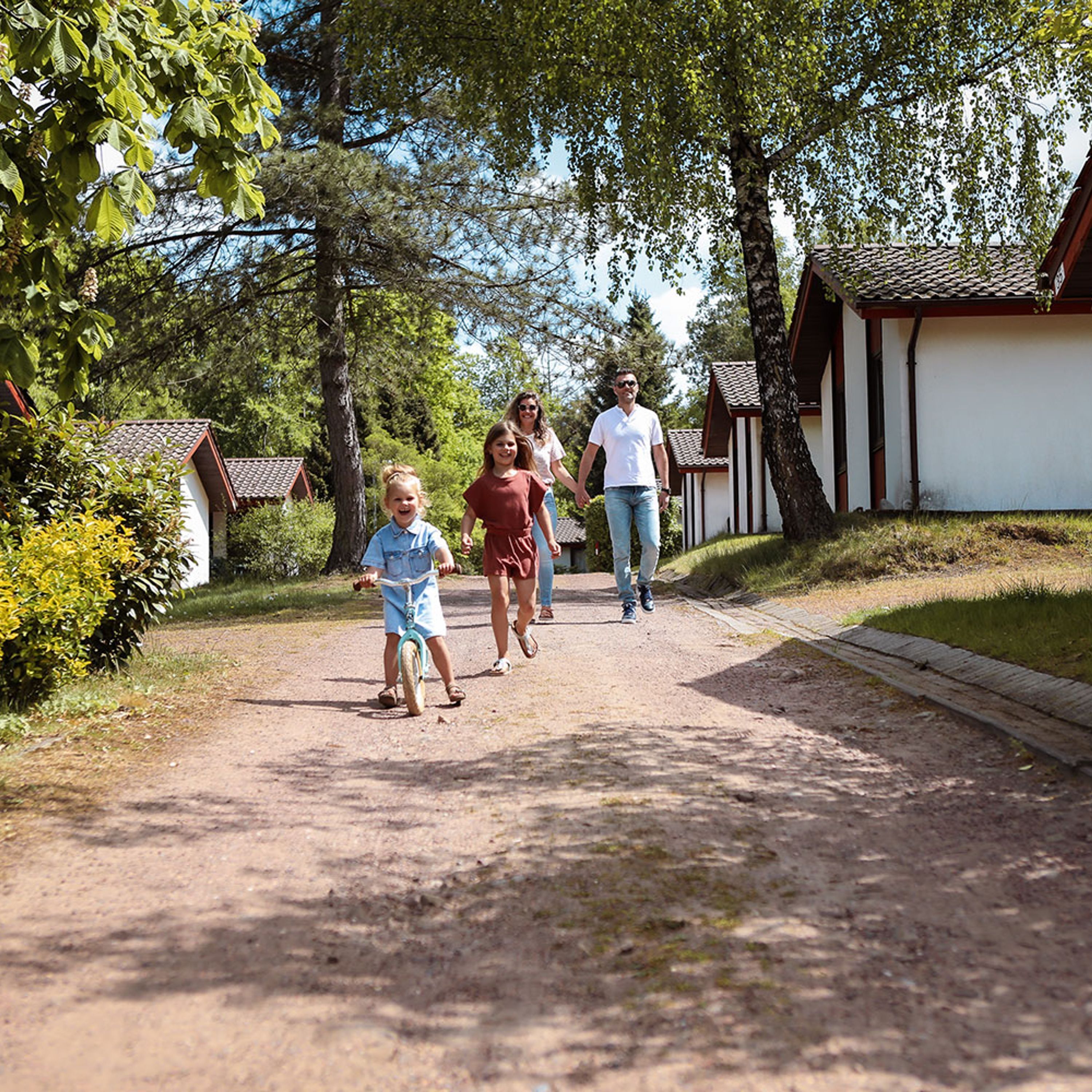 Un camino bordeado por pequeños edificios, probablemente parte de un complejo turístico o zona de vacaciones.