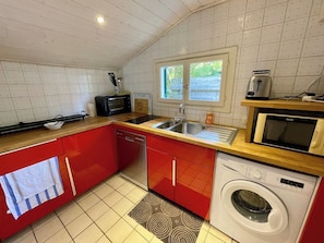A compact kitchen with a dishwasher, washing machine, microwave, and a sink. - Small bay view house in 1st line - Mimbeau A0392 (Lège-Cap-Ferret)