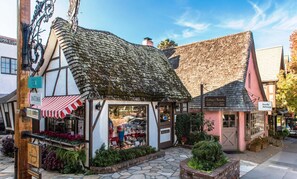 Un bâtiment traditionnel avec un toit en pente et une devanture de magasin agrémentée d’un auvent à rayures rouges et blanches.