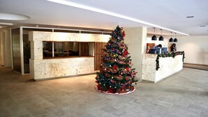 Uma área de recepção com árvore de Natal, balcão de atendimento e design de interiores moderno.