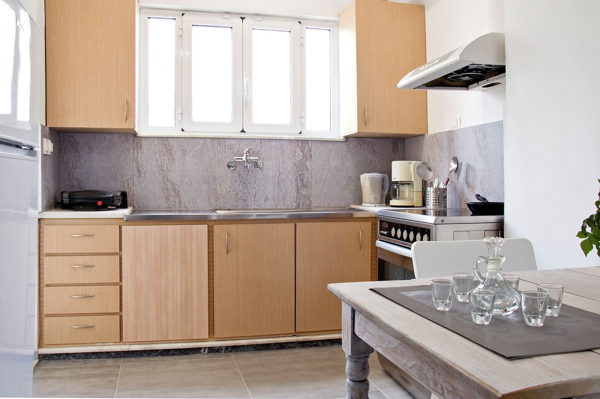 Eine moderne Küche mit Holzausstattung, einem Einbauofen und einer Kaffeemaschine.