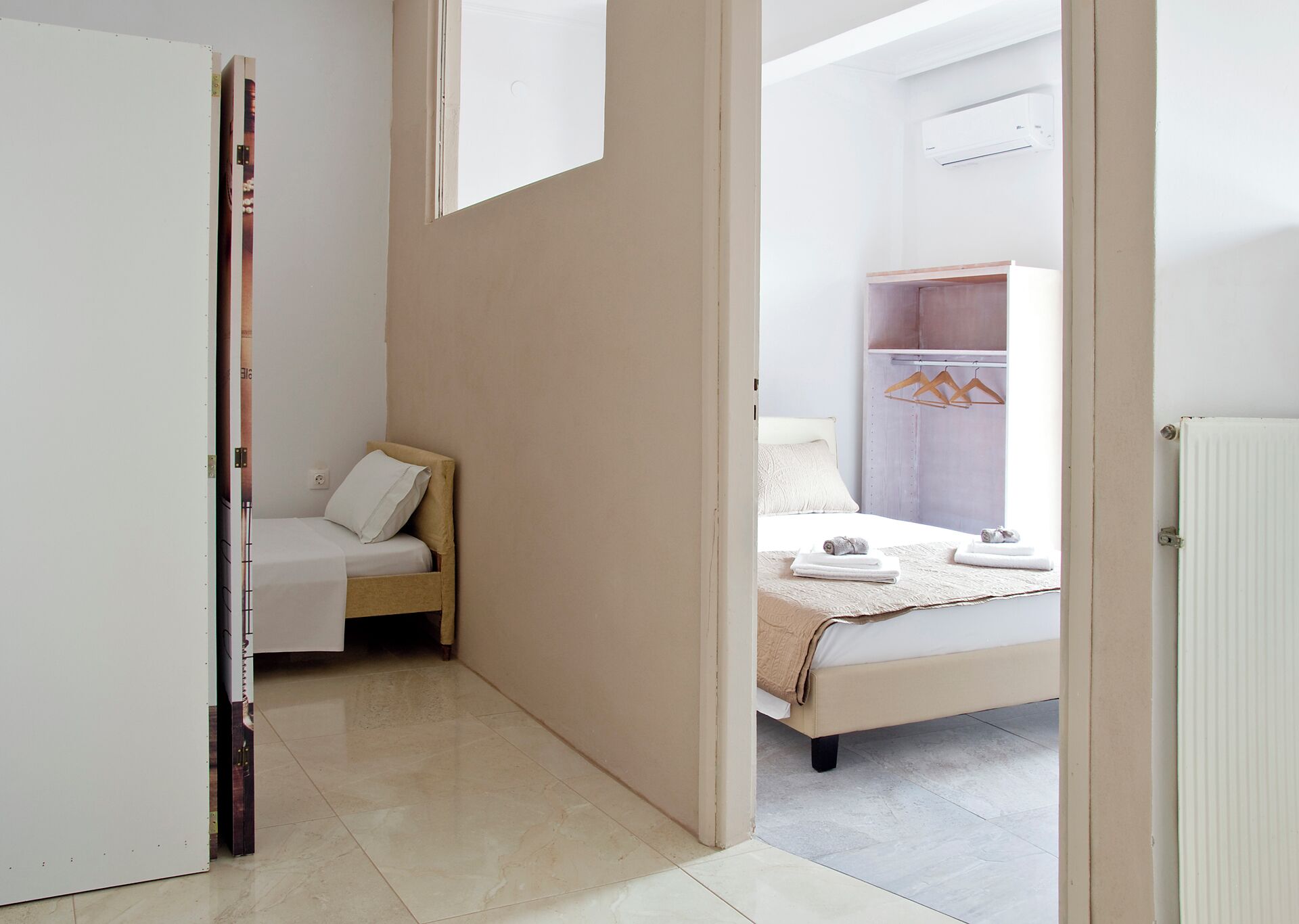 A modern bedroom with a bed, a bedside table, and a wardrobe.