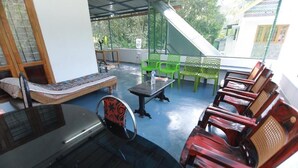 A covered outdoor seating area with a sofa, chairs, and a table.