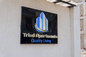 A sign for Triad Apartments with a modern design and the tagline "Quality Living".