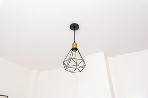 A geometric pendant light fixture hanging from a ceiling with a black cord.