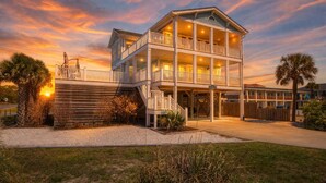 A two-story beachfront hotel with balconies, a covered walkway, and a view of the ocean. - Discover beachfront bliss at Starboard Side, Oak Island's spacious 4-bedroom retreat. (Oak Island)