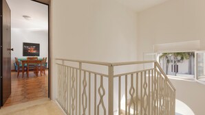 Una habitación amplia con balcón, un área de comedor con mesa y sillas, y vistas al exterior.