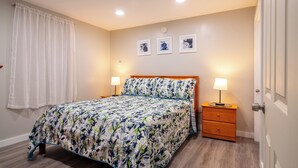 A bedroom with a bed, bedside tables, and a door. - Beautiful Apartments in Thorsen Road Maine (Hancock)
