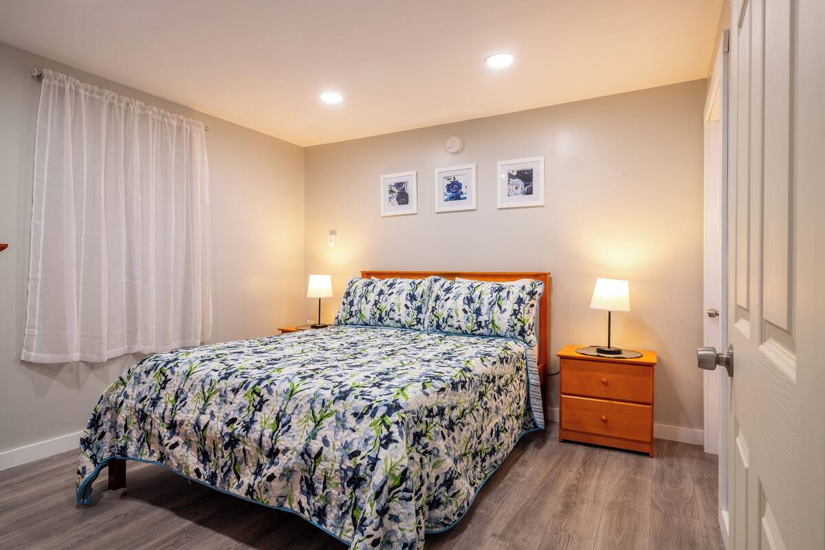 Une chambre à coucher avec un lit, des tables de chevet et une porte.