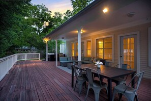 A wooden deck with a dining table and chairs, a covered seating area, and a white railing. - Bluebird Haus - Game Room & Hot Tub (Fredericksburg)