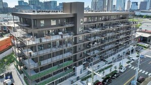 A multi-story building with a modern architectural design, featuring balconies and large windows. - Hyve-Prohibition Parlor-Pool & Gym-Mins 2 Broadway (Nashville)