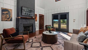 Un salón espacioso con chimenea, asientos cómodos y un ventanal con vistas al exterior.