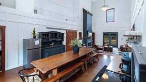 Una cocina amplia con una mesa de comedor de madera, electrodomésticos integrados y una isla grande.