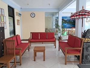A hotel lobby with a wooden sofa set, a wooden table, and a clock on the wall. - Avana Hotel Pemuteran (Pemuteran)