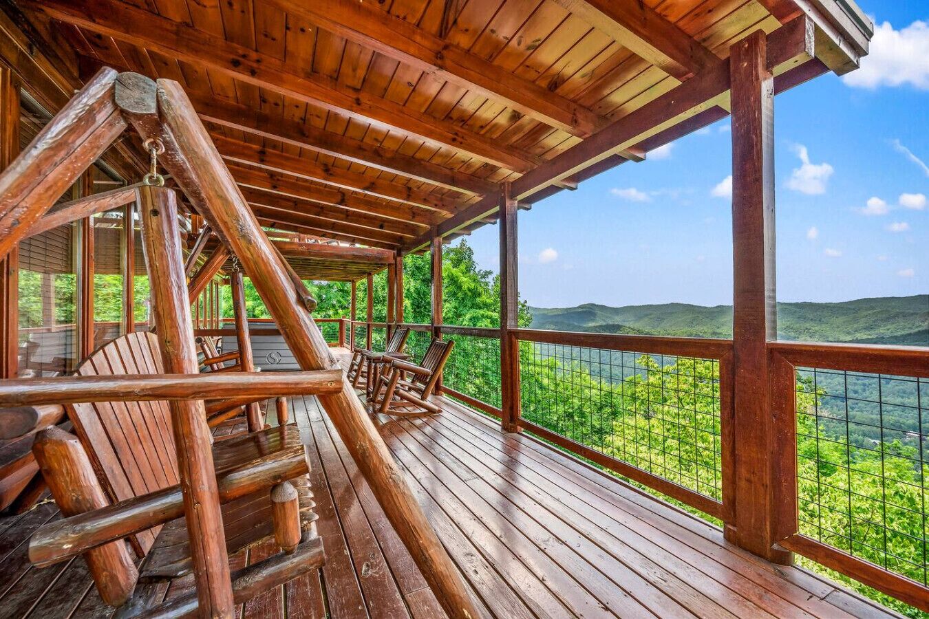 A wooden deck with a view of a lush green landscape.