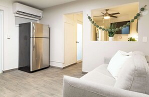 A modern kitchen with a stainless steel refrigerator, a ceiling fan, and a wall-mounted air conditioner. - AQUA Terrazas 3 · Seaside Fun & Dining with Pool (Dorado)