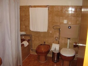 A bathroom with a bidet, toilet, and towel rack. - Casa Morgado (Almeida)