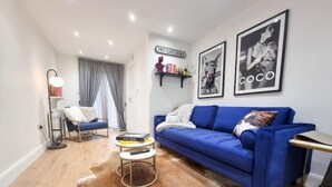 Una sala de estar moderna con un sofá azul, una mesa de centro y una estantería.