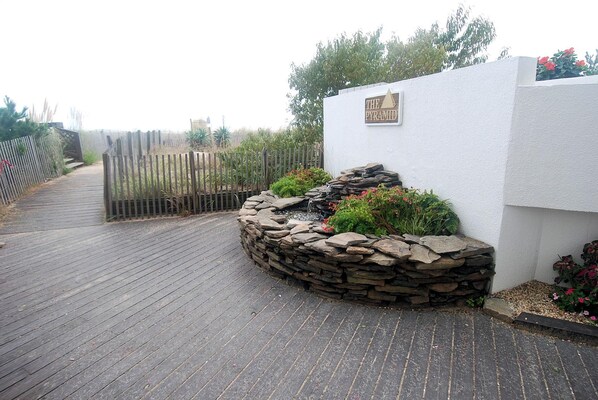 A pathway leading to a building with a sign reading 'THE PYRAMID.'