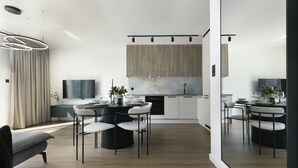 Eine moderne Küche mit Essbereich, ausgestattet mit einem runden Tisch, Stühlen und einem eingebauten Backofen.