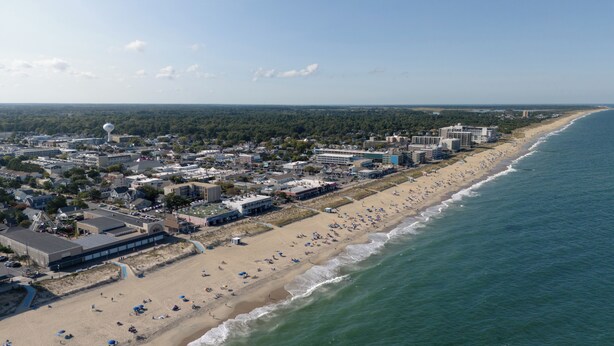 An aerial view of a coastal town with a beach, buildings, and a water tower. - Nice condo in the heart of Rehoboth! (Rehoboth Beach)