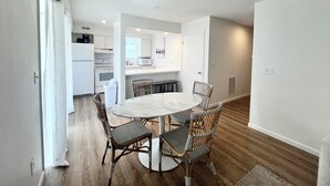 A modern kitchen with white cabinets, a microwave, and a stove. - Nice condo in the heart of Rehoboth! (Rehoboth Beach)
