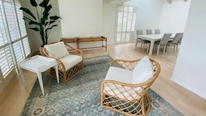 A spacious living area with a dining table and chairs, a sofa, and a coffee table.