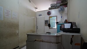 A small, dimly lit room with a desk, a chair, a clock, and a fan. There are papers on the wall and a door labeled "staff only". - Hotel O Metro Suite Apartment By Pian (Bandung)