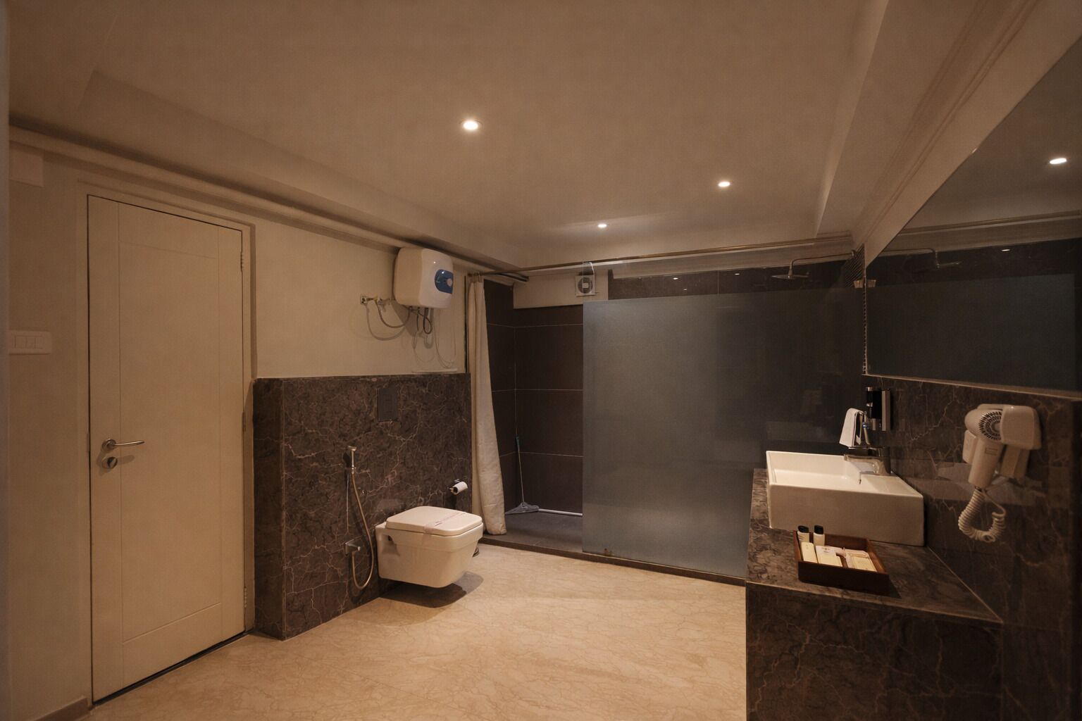 Et moderne badeværelse med toilet, bruser og håndvask.