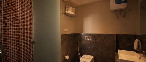 A bathroom with a toilet, sink, and shower.