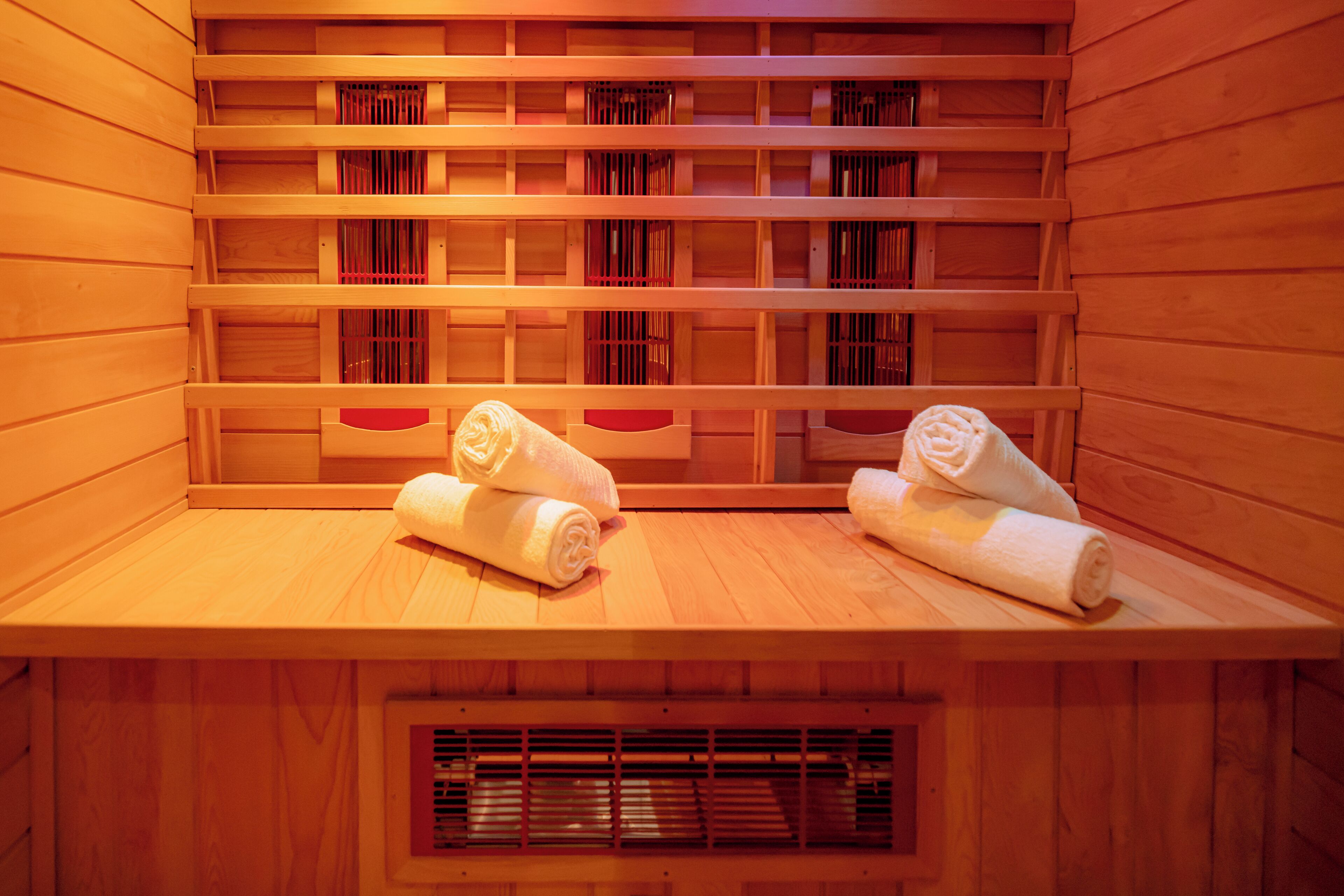 Una sauna con bancos de madera y estantes con toallas.