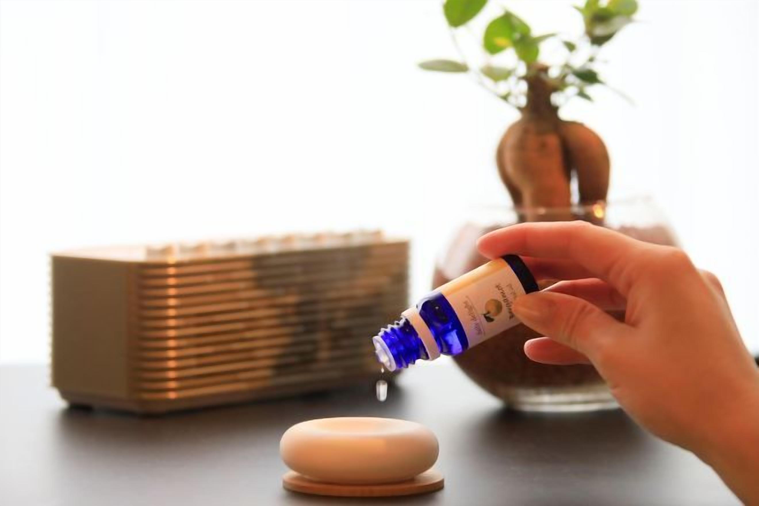 A hand pouring a liquid from a bottle into a small container.