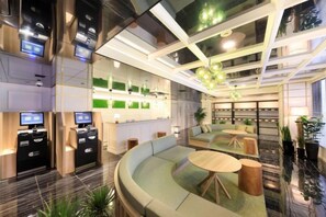 Eine moderne Hotelhalle mit einer gebogenen Sitzgruppe, einem Empfangsbereich und einer Bar.