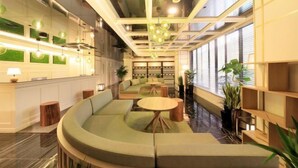 Ein modernes Interieur mit einer gebogenen Sitzgruppe, Holztischen und einer Decke mit freiliegenden Balken und hängenden Leuchten.