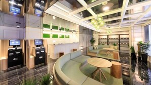 Un moderno hall de hotel con una zona de estar curvada, un mostrador de recepción y una pared decorativa verde.